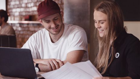 Business banker and customer looking at laptop and paper work